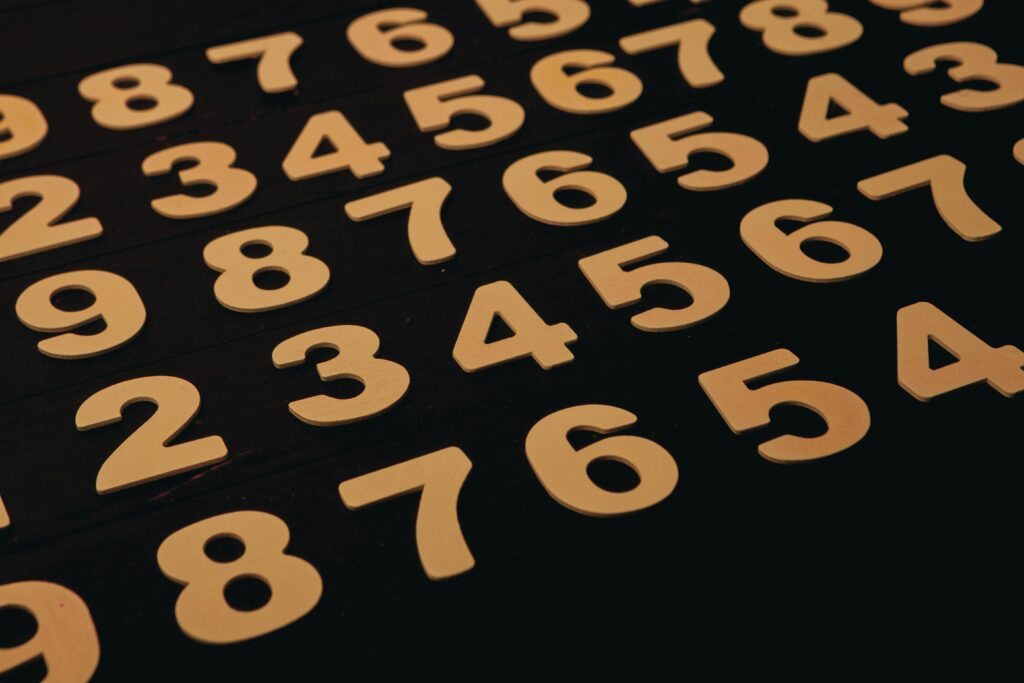 Close-up view of wooden numbers arranged on a black surface, ideal for educational themes.