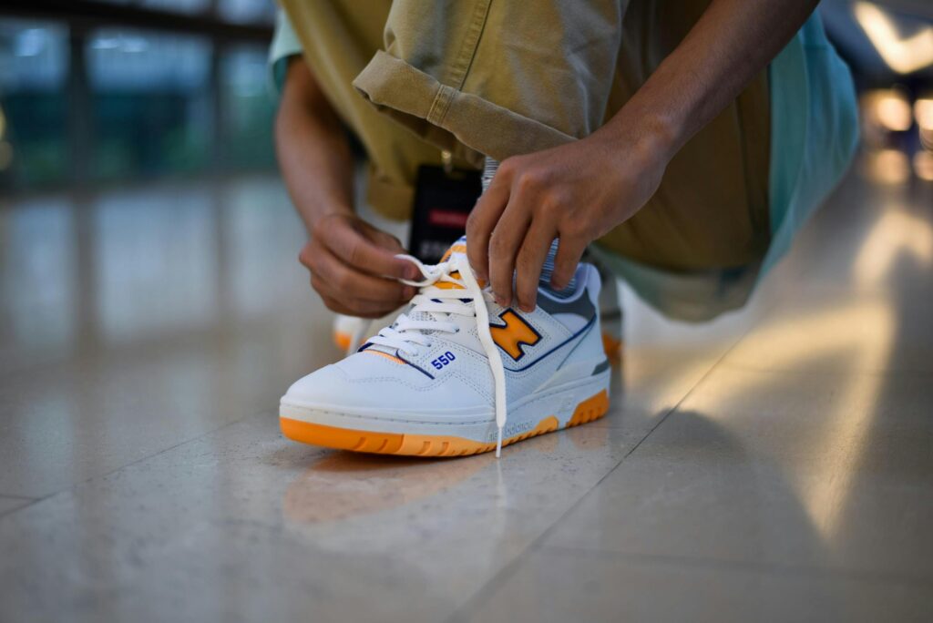 Close-up of a person tying fashionable sneakers indoors, showcasing vibrant footwear style.